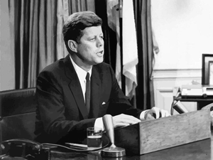 John F. Kennedy gives a speech from the resolute desk in the White House.