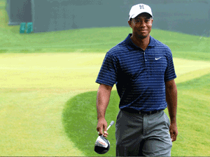 Tiger Woods smiling on a golf course.