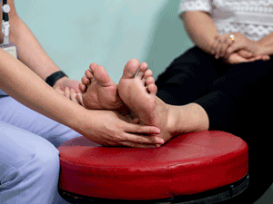 A doctor examines foot nerve response of a diabetic neuropathy patient