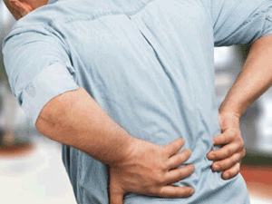 An individual with myofascial lower back pain clutches back with hands