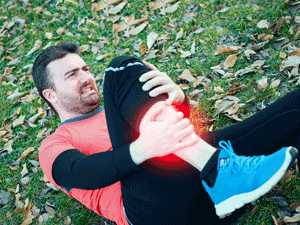Man laying on back suffering shin splint pain.