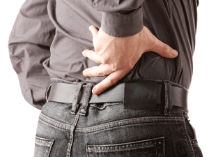 A man with lower back pain clutches his right back with his hand.
