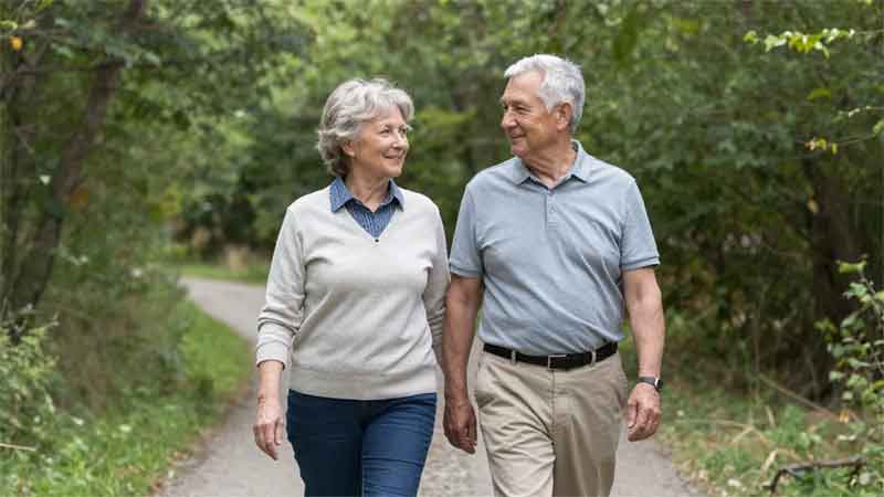 older couple walking in woods